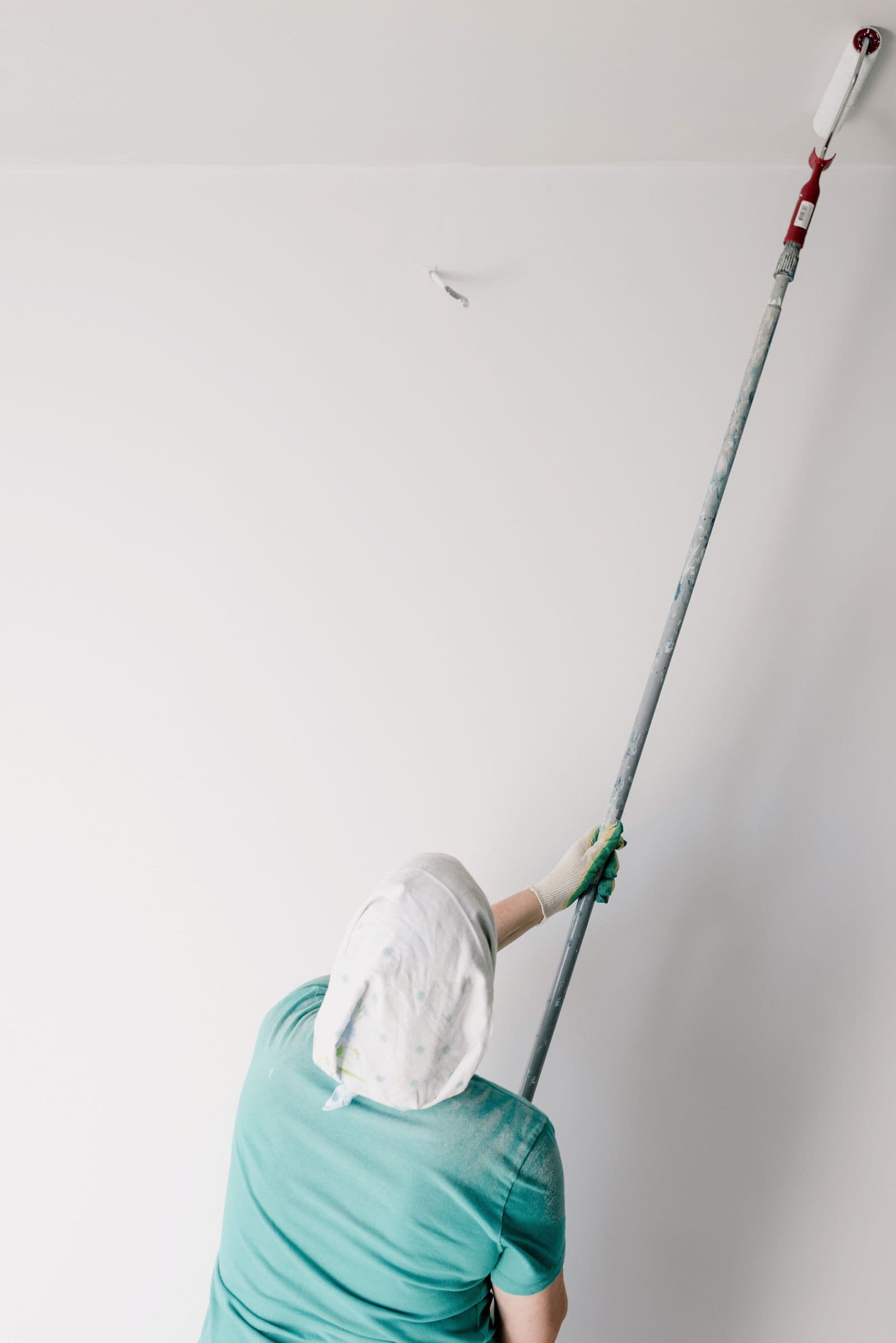 Painter rolling a ceiling with an extension pole