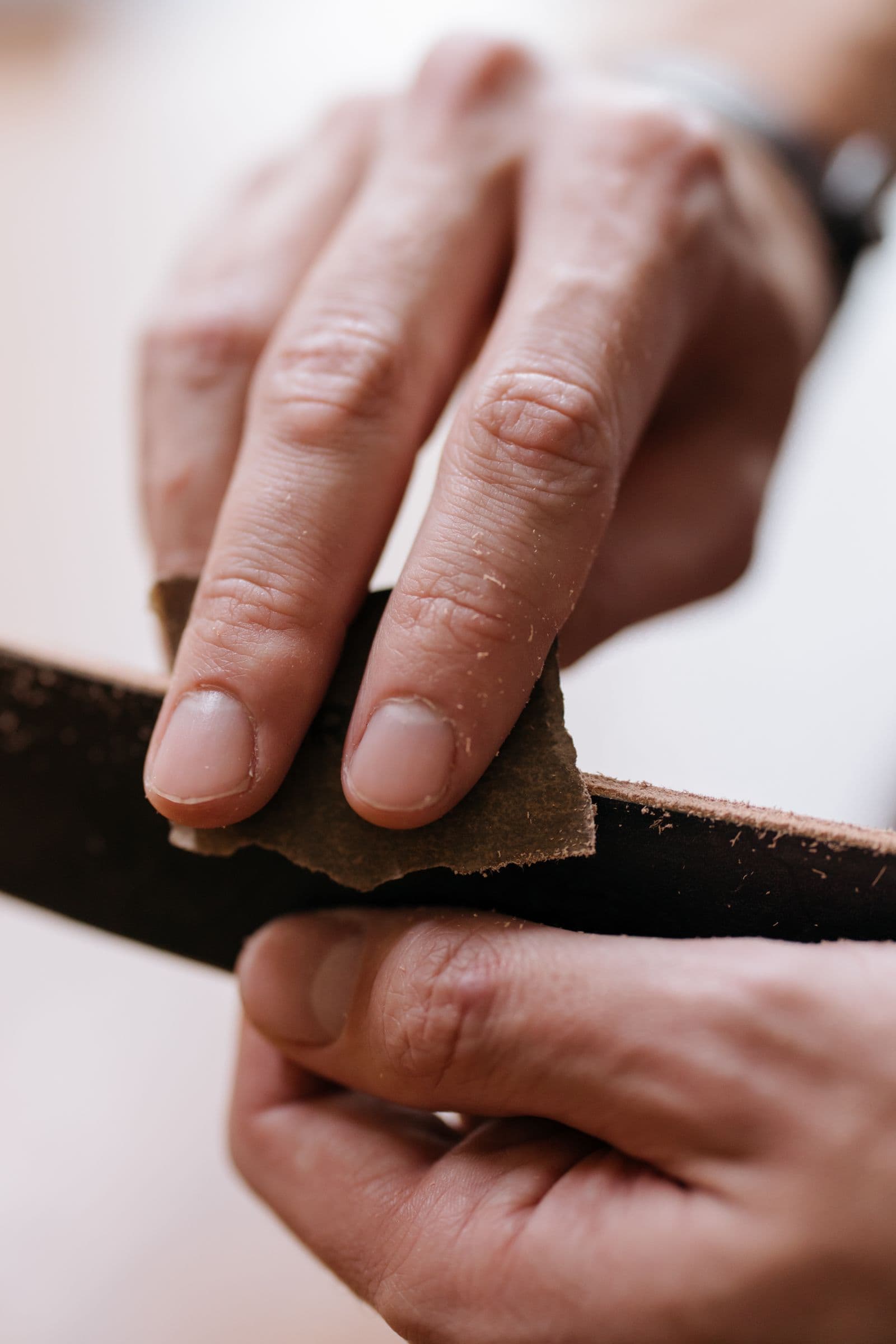 Hands sanding a wood surface by hand