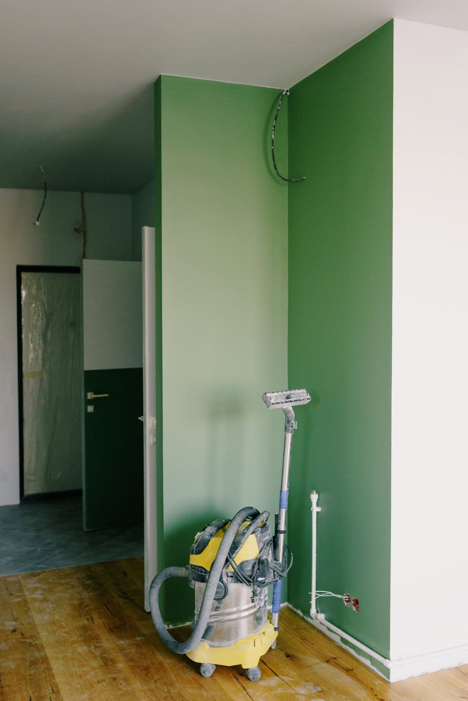 Vacuum in the corner of a freshly painted green room